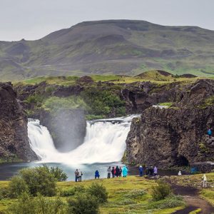 tourists looking at a small waterfall in iceland