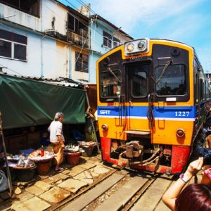 train passing by maeklong railway market