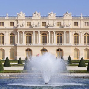 a tour guide talking to tourists inside the Palace of Versailles