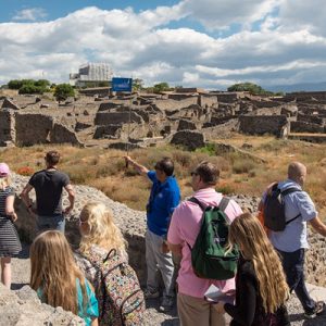 people walking around Pompeii's ruins