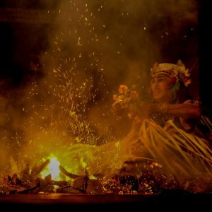 kecak dancer holding a prop above the bonfire