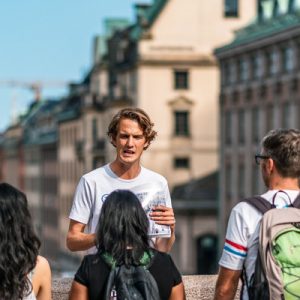 guests with tour guide with buildings behind them during the stockholm walking tour