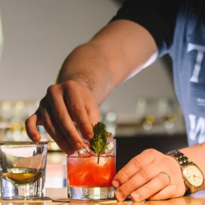 hands preparing a red cocktail