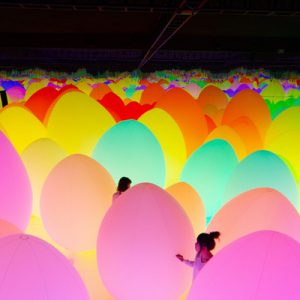 people with giant colorful eggs