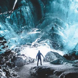 a man standing in the middle of ice cave