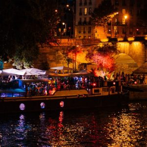 a view of the Seine River at night; there's a boat docked on the side
