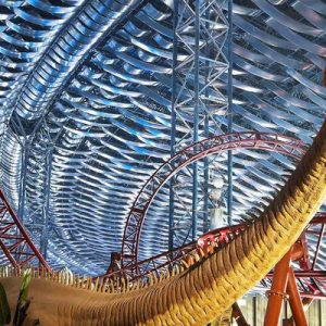 dinosaur next to indoor roller coaster in IMG Worlds of Adventure